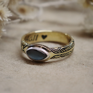 Decorative ring with blue stone on a textured surface